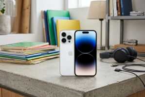 iPhone posé sur un plan de travail en béton dans un atelier avec des dossiers et un casque audio.