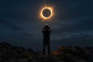 Une personne photographie une éclipse solaire avec un smartphone.