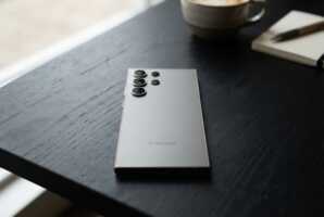 Vue arrière du smartphone Samsung S24 Ultra posé sur une surface noire.