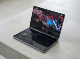Smartphone pliable ouvert affichant une vidéo sur une surface en béton.