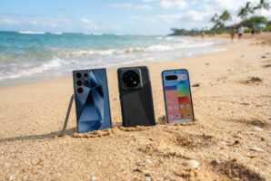 Samsung S25 Ultra, Xiaomi 15 Ultra et Google Pixel 9a posés sur le sable d'une plage.