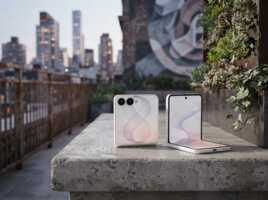Deux smartphones pliables posés sur un rebord en béton, avec une terrasse urbaine en arrière-plan.