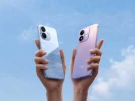 Deux mains tenant des smartphones Redmi bleu et violet sur un fond de ciel bleu.