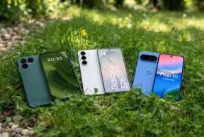 Trois smartphones posés sur de l'herbe.